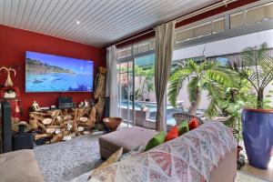 a living room with a couch and a large window at Nāhina room - City Center - Swimming Pool in Papeete