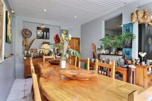 a dining room with a wooden table and chairs at Fare Nãhina - 2 Bedrooms - City Center - Swimming Pool in Papeete