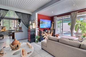 a living room with a couch and a table at Fare Nãhina - 2 Bedrooms - City Center - Swimming Pool in Papeete
