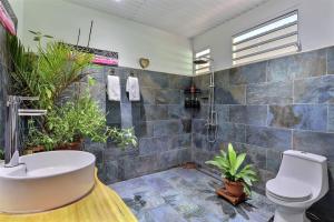 a bathroom with a sink and a toilet and plants at Fare Nãhina - 2 Bedrooms - City Center - Swimming Pool in Papeete +16 photos