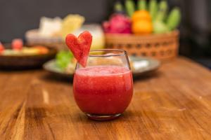 a drink with a heart in a glass on a table at Taman Kencana Ubud in Ubud