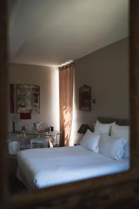 a bedroom with a large white bed and a table at Château de la Bousquetarie in Lempaut
