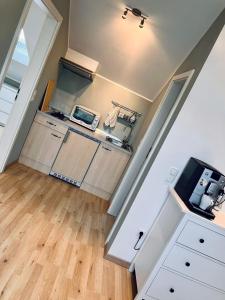a kitchen with white cabinets and a counter top at Moderne Dachgeschosswohnung an der Donau in Mariaposching +5 photos