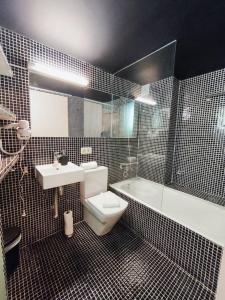 une salle de bain avec toilettes, lavabo et baignoire dans l'établissement Apartamento Loft Desing City Center, à Tolède