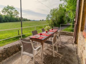 una mesa y sillas en un patio con vistas a un campo en Pool Escape in Saint-Laurent, en Saint-Laurent-la-Vallée