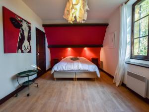 Un dormitorio con una cama con una pared roja. en Pool Escape in Saint-Laurent, en Saint-Laurent-la-Vallée