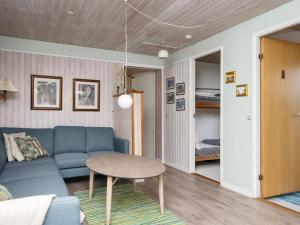 a living room with a blue couch and a table at 8 person holiday home in Struer in Struer