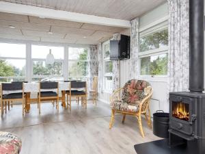 a living room with a fireplace and a table and chairs at 8 person holiday home in Struer in Struer +35 photos