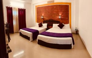 two beds in a hotel room with two beds sidx sidx sidx at Restinn Homestay in Thekkady