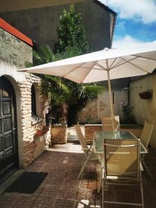 ein Tisch und Stühle mit einem Sonnenschirm auf einer Terrasse in der Unterkunft maison avec patio in Grand-Fort-Philippe
