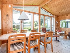 a dining room with a wooden table and chairs at 6 person holiday home in Ringkøbing in Ringkøbing