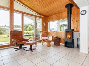a living room with a wood stove and a chair at 6 person holiday home in Ringkøbing in Ringkøbing
