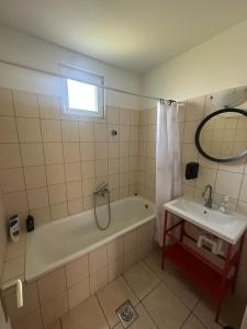 a bathroom with a bath tub and a sink at Heera Apartmans in Hajdúszoboszló +10 photos