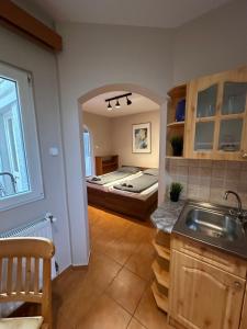 a kitchen with a sink and a bed in a room at Heera Apartmans in Hajdúszoboszló