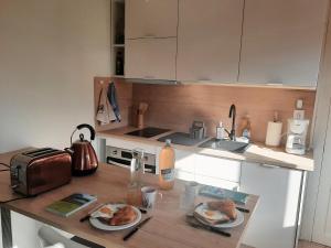 a kitchen with a table with plates of food on it at Maisonnette au bord du Sierroz in Aix-les-Bains