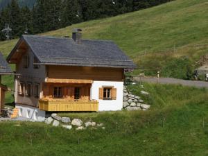 a small house on a hill in a field at Chalet in Sankt Gallenkirch near Ski Bus in Sankt Gallenkirch