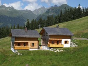 a house on a hill with mountains in the background at Chalet in Sankt Gallenkirch near Ski Bus in Sankt Gallenkirch