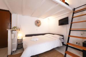 a bedroom with a white bed and a ladder at PrimoPiano - Pacini in Milan