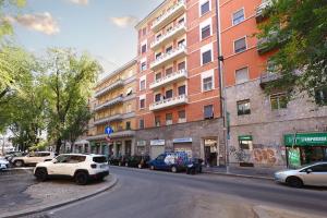 a street with cars parked in front of a tall building at PrimoPiano - Pacini in Milan