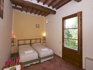 a bedroom with two beds and a window at Tuscan Hilltop Farm Stay in Castelnuovo Berardenga