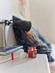 a candle sitting on a table next to books at Ferienwohnungen am Wildpark Müden-Örtze in Faßberg