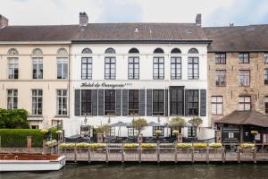 a large building next to a river with a boat at Hotel De Orangerie by CW Hotel Collection - Small Luxury Hotels of the World in Bruges