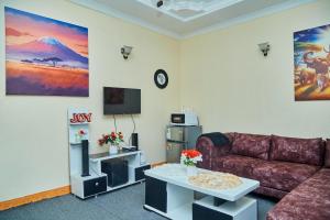 a living room with a couch and a table at Mella home Arusha in Marombosa