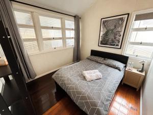 a bedroom with a bed and two windows at Brisbane Rooms in Brisbane