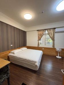 a bedroom with a large bed and a window at Fengming B&B in Jinning