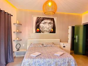 a bedroom with a bed with a picture of a woman at Enigma Casa Preá in Cruz +32 photos
