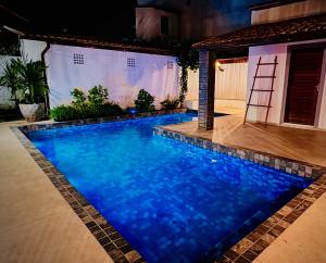 a swimming pool with blue water in a house at Enigma Casa Preá in Cruz