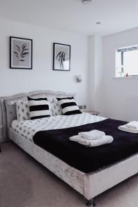 a bedroom with a large bed with black and white sheets at Seek Hythe in Hythe