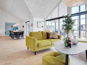 a living room with a yellow couch and a table at 5 star holiday home in Sydals in Sarup +68 photos