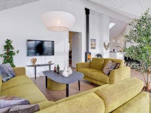 a living room with two yellow couches and a table at 5 star holiday home in Sydals in Sarup