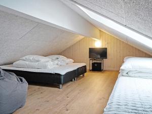a attic bedroom with two beds and a flat screen tv at 5 star holiday home in Sydals in Sarup