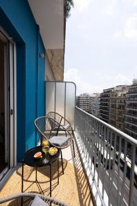 a balcony with two chairs and a glass of wine at Boho style 2BD in Thessaloniki