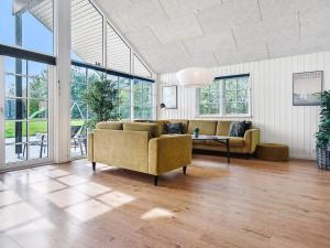 a living room with a couch and a table and windows at 5 star holiday home in Sydals in Sarup