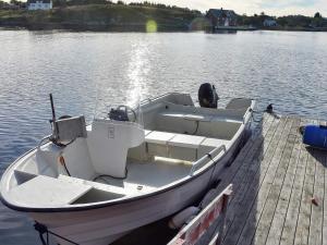 a white boat is docked at a dock at 6 person holiday home in Bud in Bud