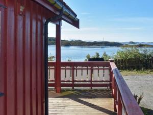 a red building with a view of a body of water at 6 person holiday home in Bud-By Traum in Bud