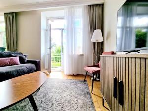 a living room with a couch and a tv at Central Stay Appartments in Šiauliai