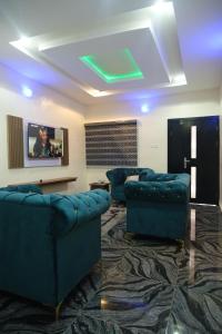 a waiting room with blue chairs and a tv at Tway apartment in Ilorin