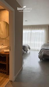 a bedroom with a bed and a bathroom with a sink at Hotel BIOCERRO in Tandil