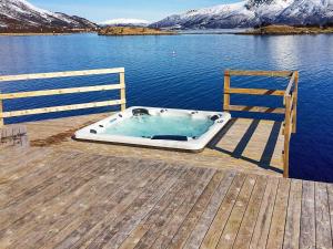einen Whirlpool auf einem Dock neben dem Wasser in der Unterkunft 11 person holiday home in Gullesfjord in Flesnes + 20 Fotos