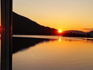 einen Sonnenuntergang über einem Wasserkörper mit Sonnenuntergang in der Unterkunft 11 person holiday home in Gullesfjord in Flesnes