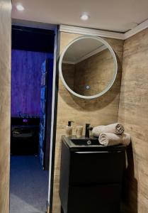 a bathroom with a sink and a mirror at LOVE IN CINÉ Appartement cinéma balnéo in Pamiers