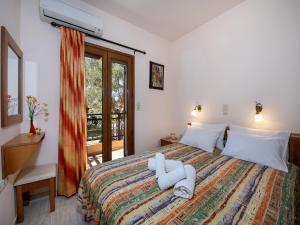 a bedroom with a bed and a desk and a window at Villa in Crete near Beach and Olive Groves in Pangalochori