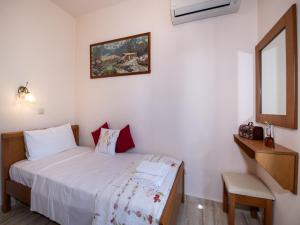 a small bedroom with a bed and a mirror at Villa in Crete near Beach and Olive Groves in Pangalochori