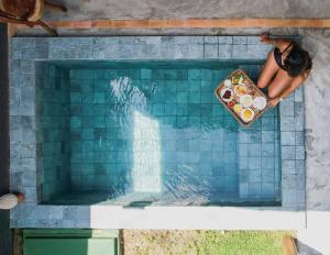 une personne dans une piscine avec une assiette de nourriture dans l'établissement Pousada Nori - Por MME Hospitalidade, à São Miguel dos Milagres 33 autres photos
