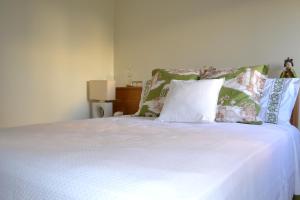 Un dormitorio con una cama con sábanas y almohadas blancas. en All in One City Flat - Pool, parking & nomad, en Lisboa 8 fotos más