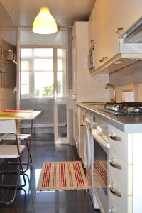 cocina con fogones, mesa y ventana en All in One City Flat - Pool, parking & nomad, en Lisboa
